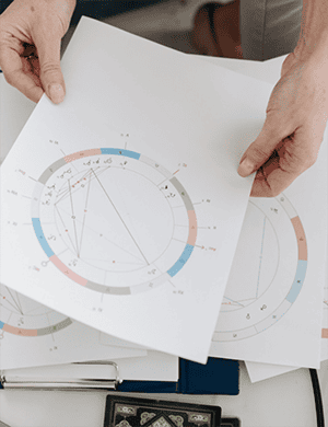 Astrological charts and natal diagrams being examined for personalized birth analysis.