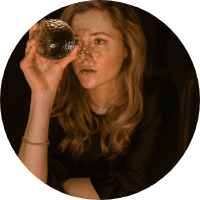 Glass of red wine being sipped by a young woman at a social gathering.