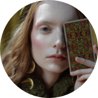 Elegant woman holding a patterned mirror, showcasing fashion accessories and beauty.