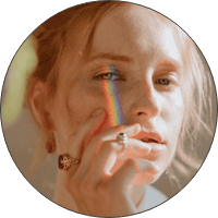 Colorful rainbow makeup on a young woman's face showcasing artistic beauty trends.